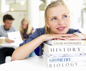 Young girl with hands on books at school